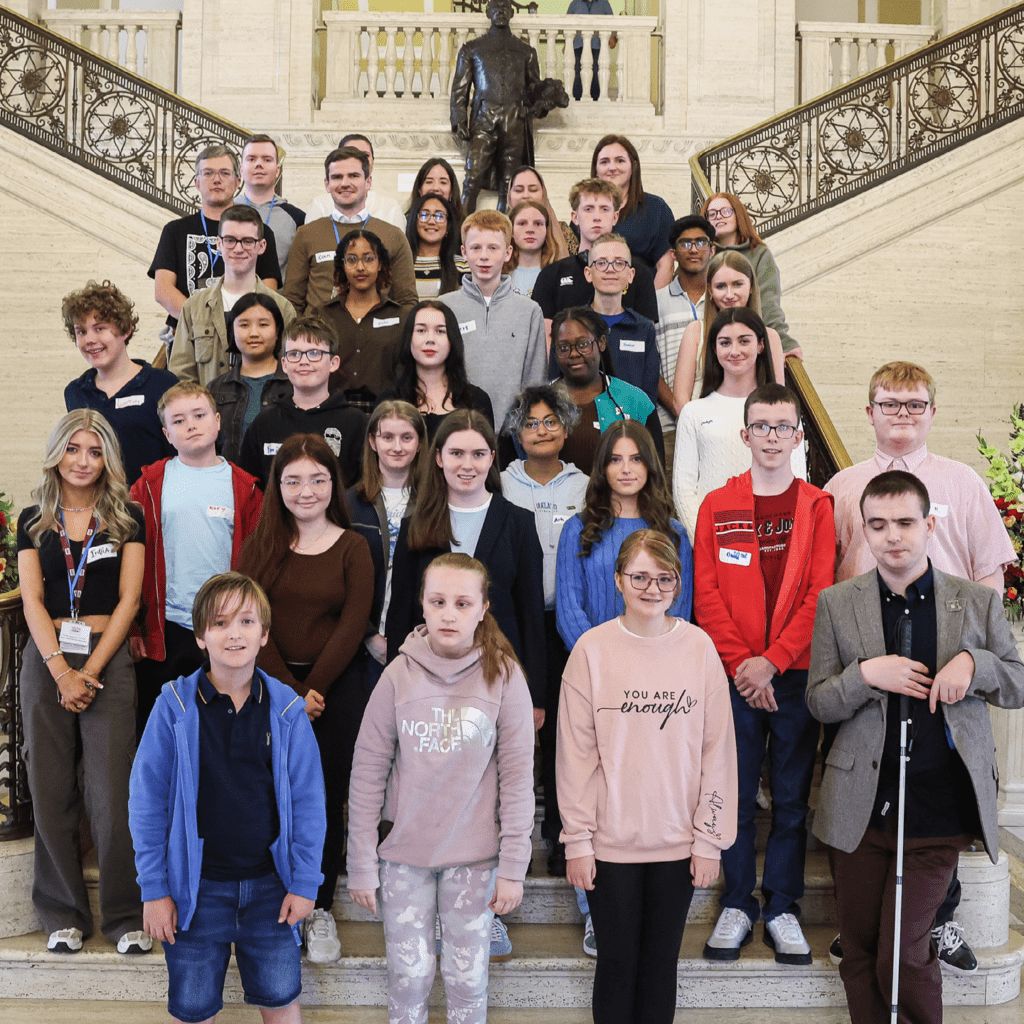 Image of a group of young people standing on the steps of The Great Hall in Stormont's Parliament Buildings.